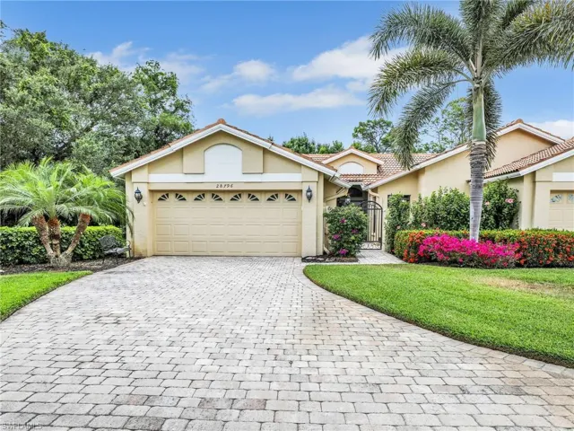Ranch-style house featuring a front yard, decorative driveway, stucco siding, a gate, and an attached garage