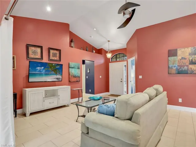 Living room with baseboards, high vaulted ceiling, recessed lighting, a ceiling fan, and light tile patterned floors