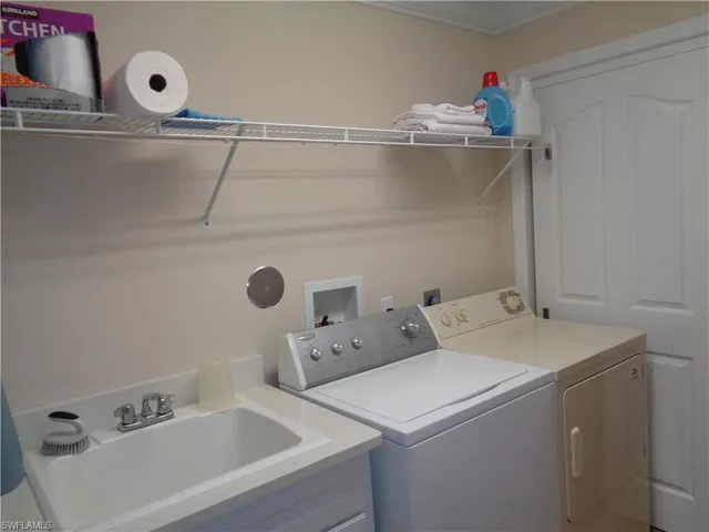 Washroom featuring washer and clothes dryer and ornamental molding