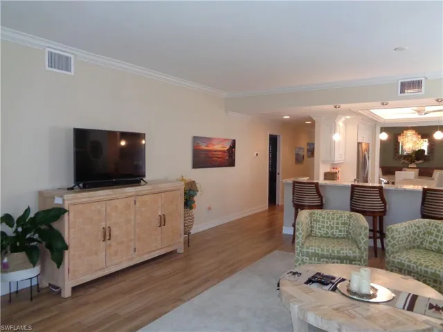 Living area featuring wood finished floors and ornamental molding
