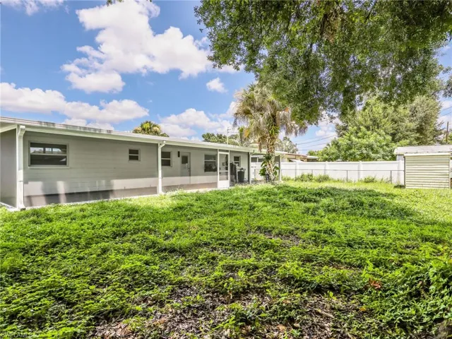 Expansive backyard featuring a covered patio, a storage shed, and a privacy fence