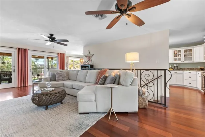 Living room with dark wood-type flooring and a ceiling fan