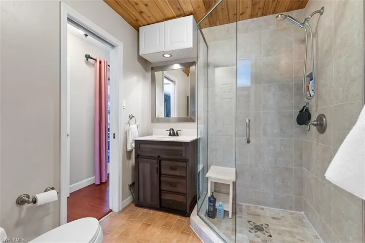 Bathroom featuring vanity, wooden ceiling, a stall shower, and wood finish floors