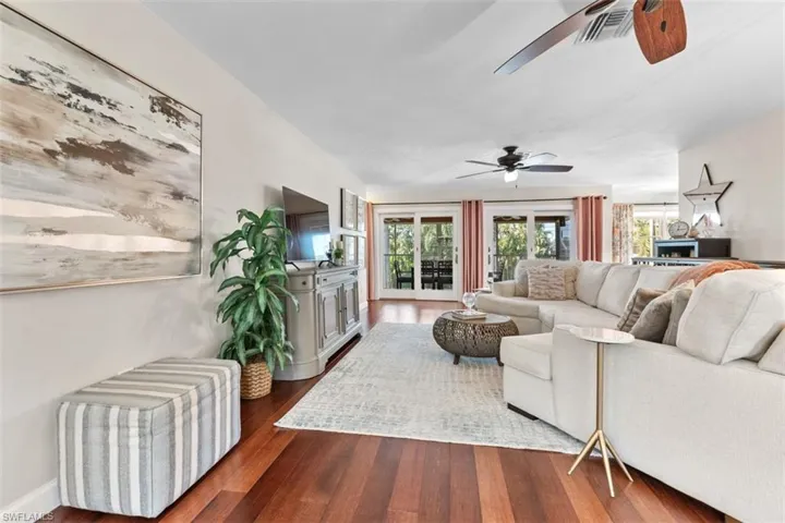 Living room featuring dark wood-style flooring and a ceiling fan