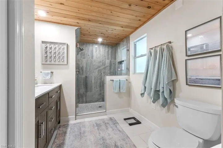 Master bath featuring wood ceiling, vanity, walk in shower, light tile patterned floors, and recessed lighting