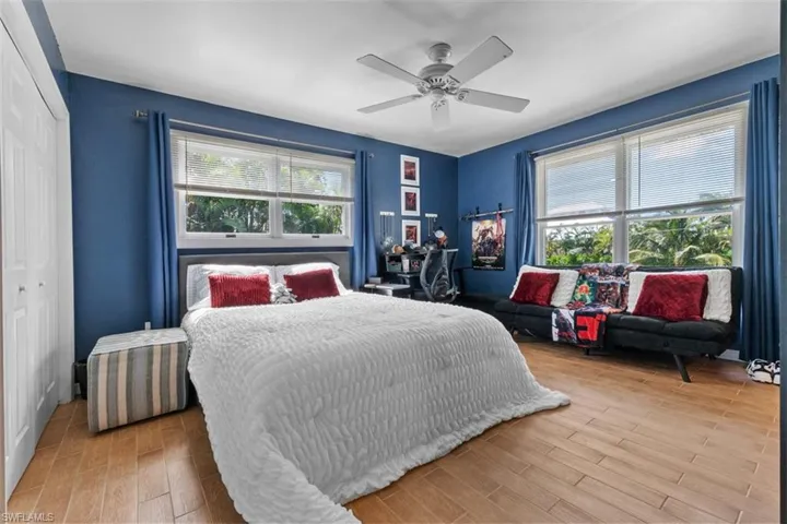 Bedroom with a closet, light wood-style flooring, and a ceiling fan