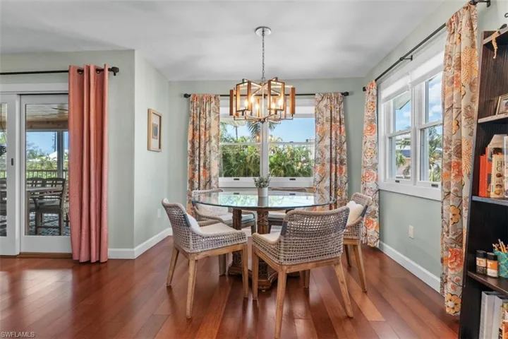 Dining room with dark wood-style floors and a chandelier
