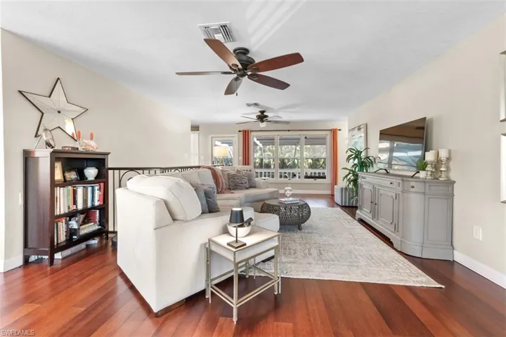 Living area featuring dark wood-type flooring and a ceiling fan
