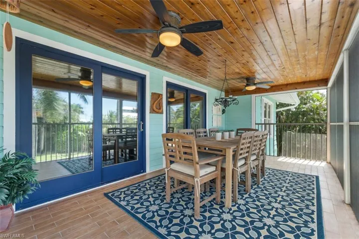 Sunroom with outdoor dining area and a ceiling fan