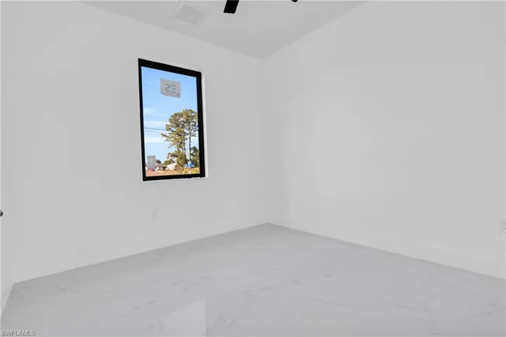 Empty room featuring visible vents, baseboards, marble finish floor, and ceiling fan
