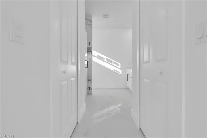 Corridor featuring marble finish floor and baseboards