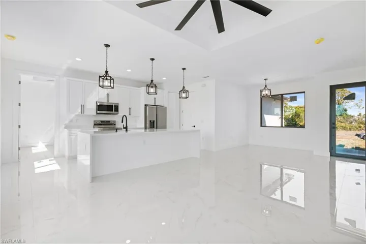 Kitchen with white cabinets, appliances with stainless steel finishes, marble finish floor, light countertops, and recessed lighting