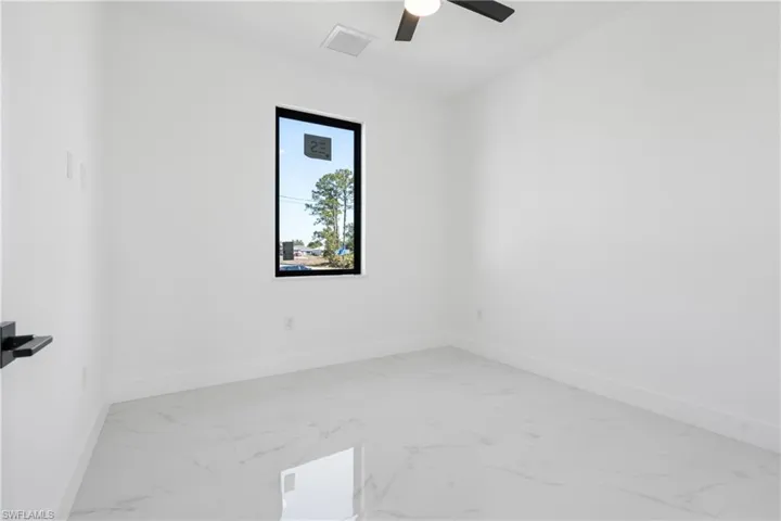 Unfurnished room with visible vents, baseboards, marble finish floor, and ceiling fan