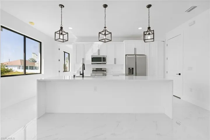 Kitchen featuring marble finish floor, appliances with stainless steel finishes, a sink, and visible vents