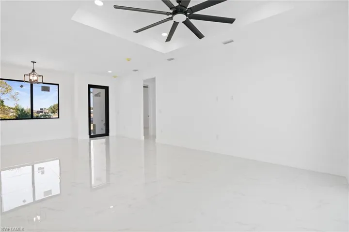 Unfurnished room with a tray ceiling, marble finish floor, recessed lighting, visible vents, and baseboards