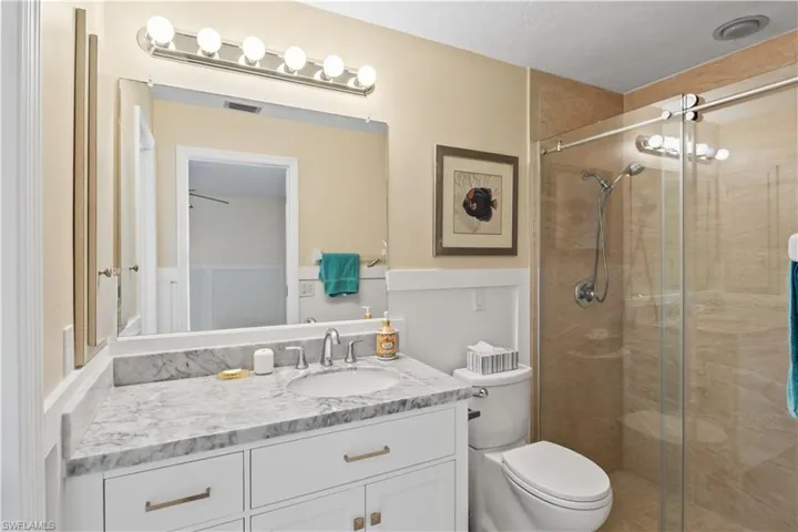Full bathroom with walk-in shower, and ample storage, offering comfort and privacy.