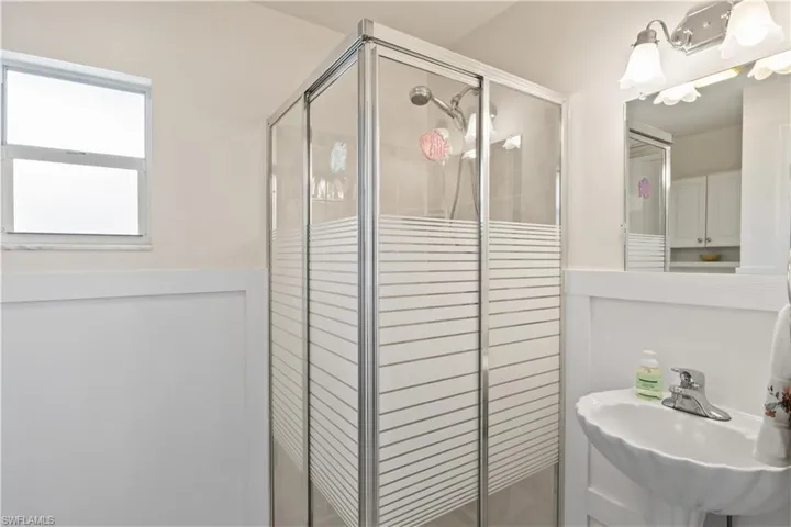 Guest bathroom with updated finishes and walk-in shower next to the sunroom.