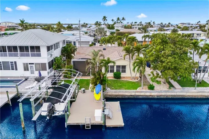 Stunning aerial perspective of the home’s private dock, showcasing waterfront access, boat lift, and serene canal surroundings — perfect for boating and outdoor enjoyment.