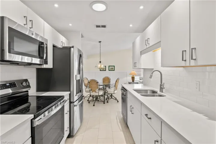 Kitchen seamlessly connects to the dining and living areas, equipped with stainless steel appliances for both style and convenience.