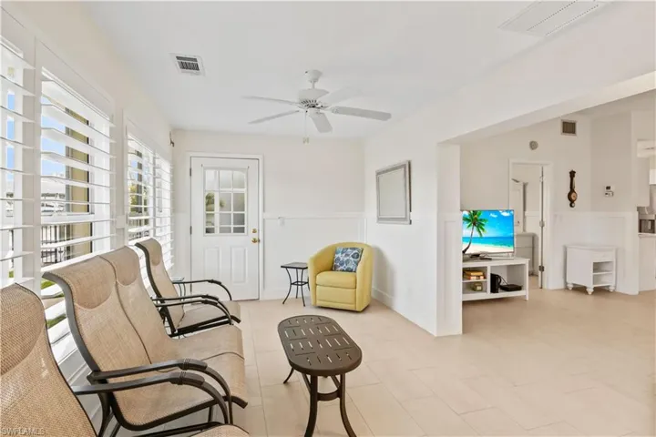 Light-filled sunroom with large windows and a door leading directly to the backyard, perfect for relaxing or enjoying views of the canal.