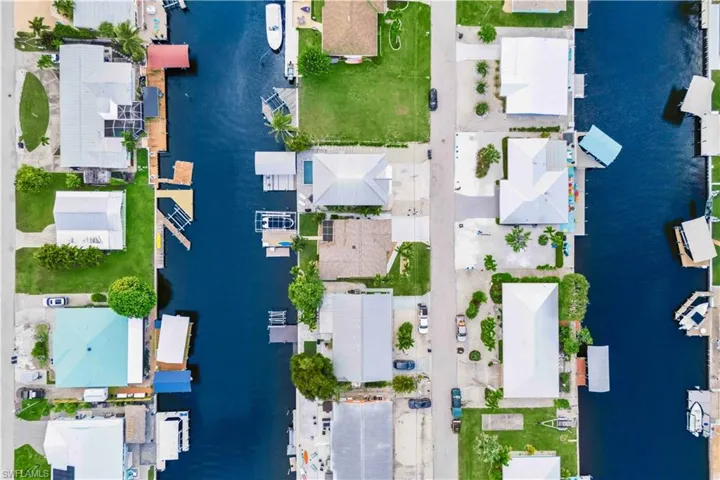Bird’s-eye view highlighting the home’s roofline, lot layout, and surrounding waterfront setting, showcasing its prime location and scenic surroundings.