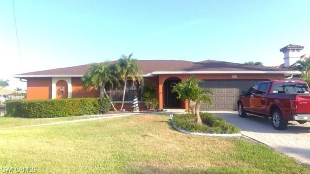 Single-story residence featuring an orange stucco exterior, a brown shingle roof, and an arched entryway