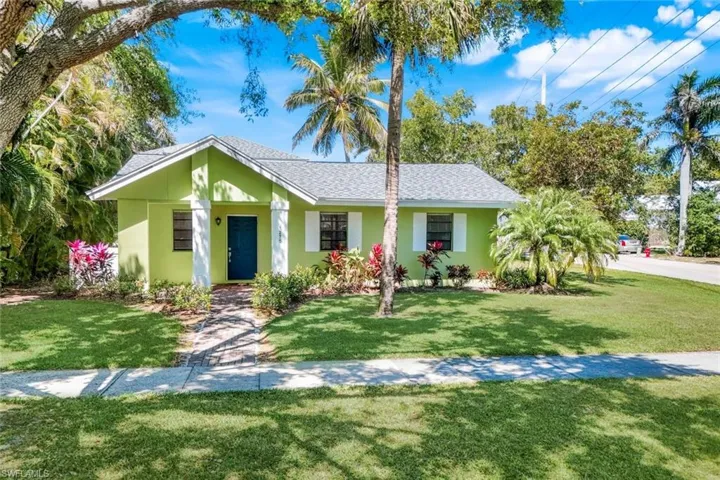 Ranch-style house featuring a shingled roof, a front lawn, and stucco siding