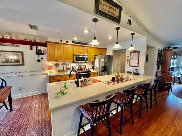 QUARTZ TOPS with large breakfast bar and pendant lighting.