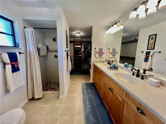 Dual sinks, walk in shower and large walk in closet with built in closet shelving.