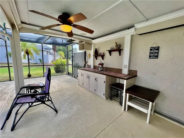 Covered patio overlooking the pool area with built in cabinets and counterspace.