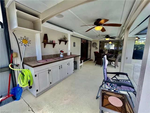 Covered patio overlooking the pool area with built in cabinets and counterspace.