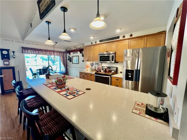 QUARTZ TOPS with large breakfast bar and pendant lighting.