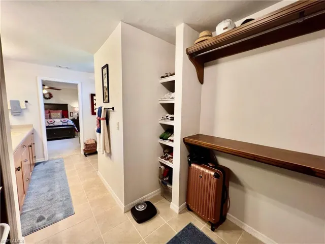 Primary walk in closet with custom built in shelving.