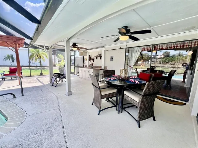 Covered patio overlooking the pool area with built in cabinets and counterspace