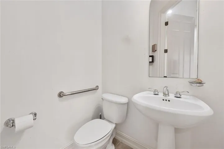 Bathroom featuring tile patterned floors, toilet, and sink