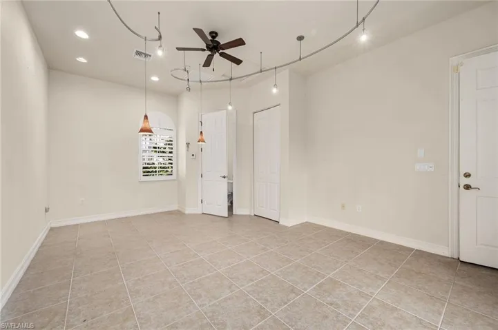 Spare room with ceiling fan, light tile patterned floors, and track lighting