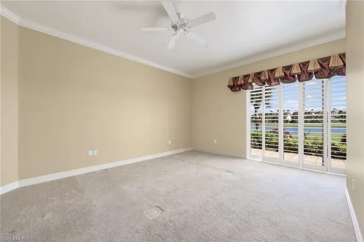 Carpeted empty room with ceiling fan and crown molding