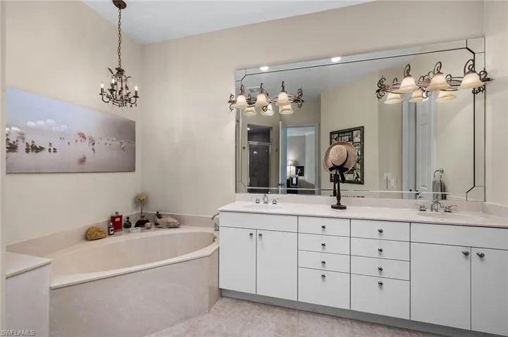 Bathroom featuring tile patterned flooring, shower with separate bathtub, and vanity
