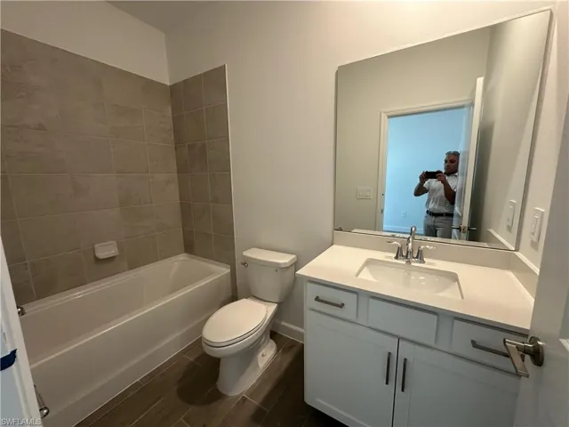 Full bathroom with toilet, vanity, and tiled shower / bath