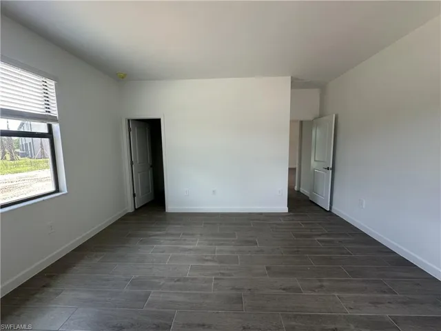 Unfurnished bedroom with dark tile patterned flooring