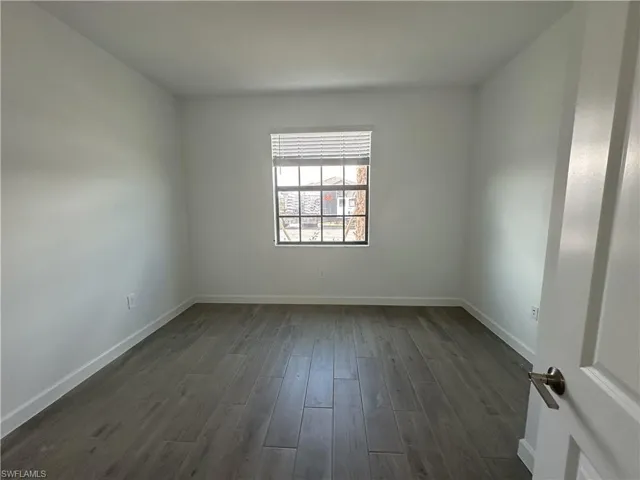 Spare room with dark wood-type flooring