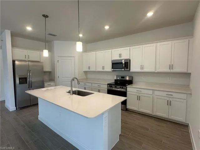 Kitchen featuring sink, white cabinets, and stainless steel appliances