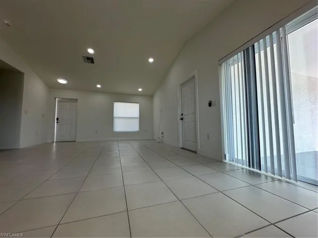 Unfurnished room with lofted ceiling, recessed lighting, and tile patterned floors