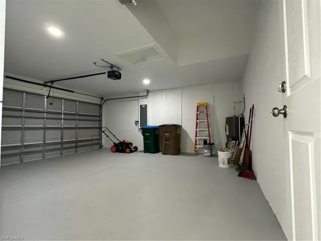 Garage featuring a garage door opener and water heater