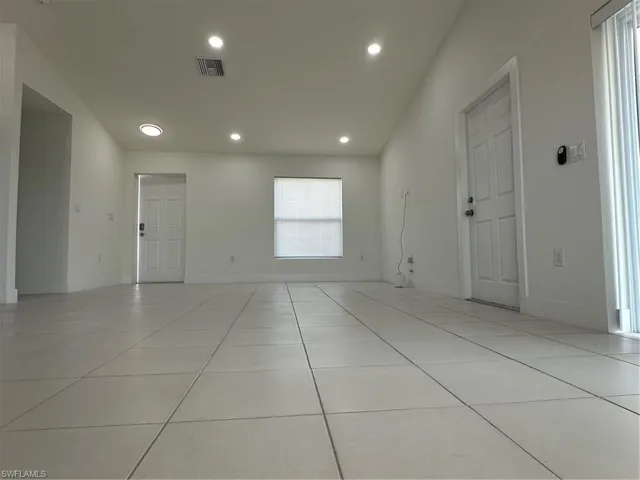 Empty room with light tile patterned flooring, baseboards, and recessed lighting