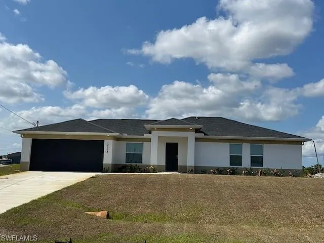 Prairie-style house with stucco siding, a garage, and concrete driveway