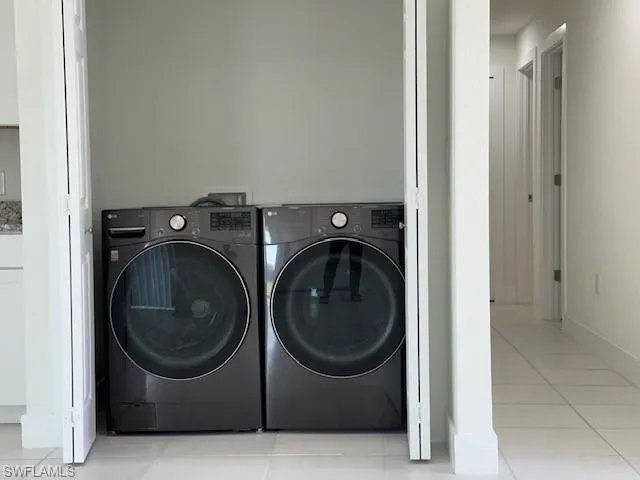 Laundry area with washing machine and dryer and tile patterned floors