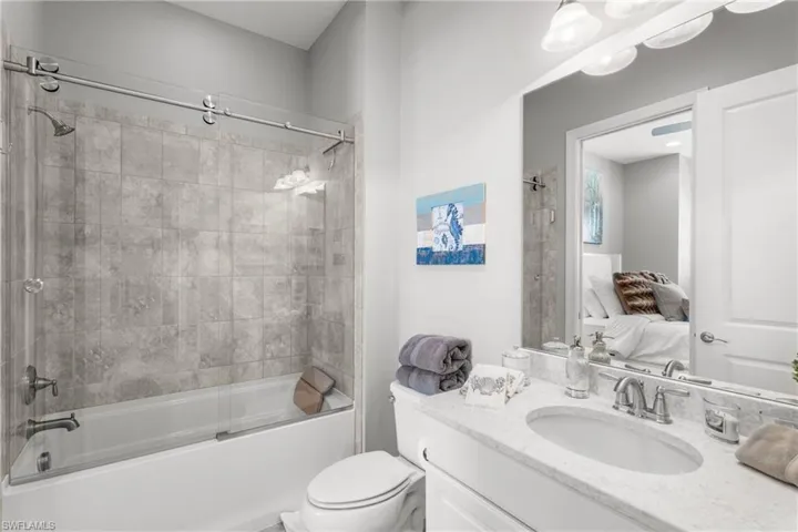 Ensuite bathroom with vanity, shower / washtub combination, and toilet