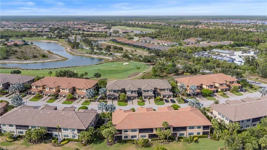 Aerial overview of property's location with a golf course, nearby suburban area, and a nearby body of water