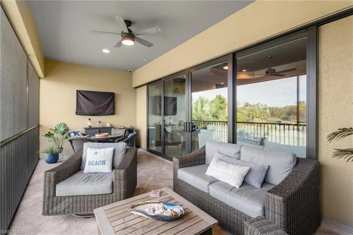 Sunroom / solarium featuring a ceiling fan, outdoor dining space, and a textured wall